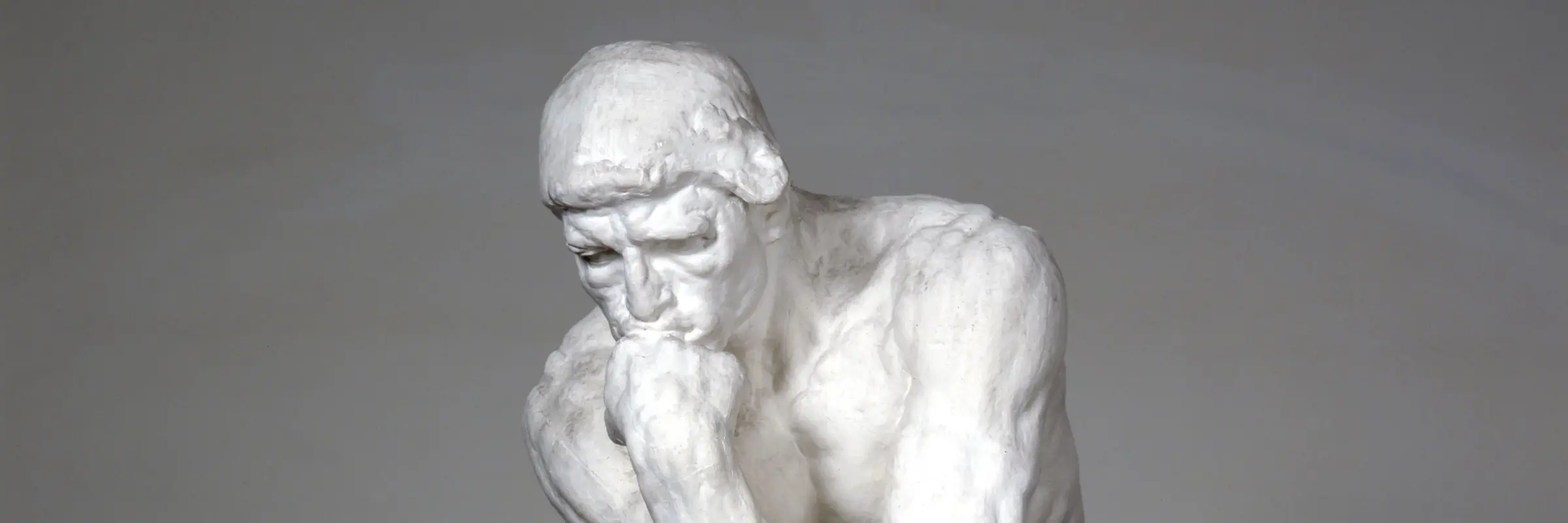 Skulptur eines sitzenden Mannes, Hand am Kinn