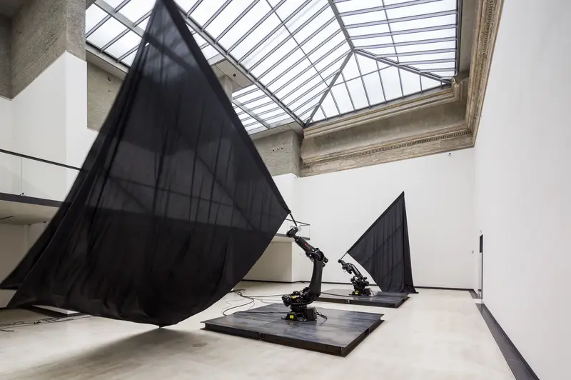 zwei Roboter-Arme mit schwarzen Fahnen