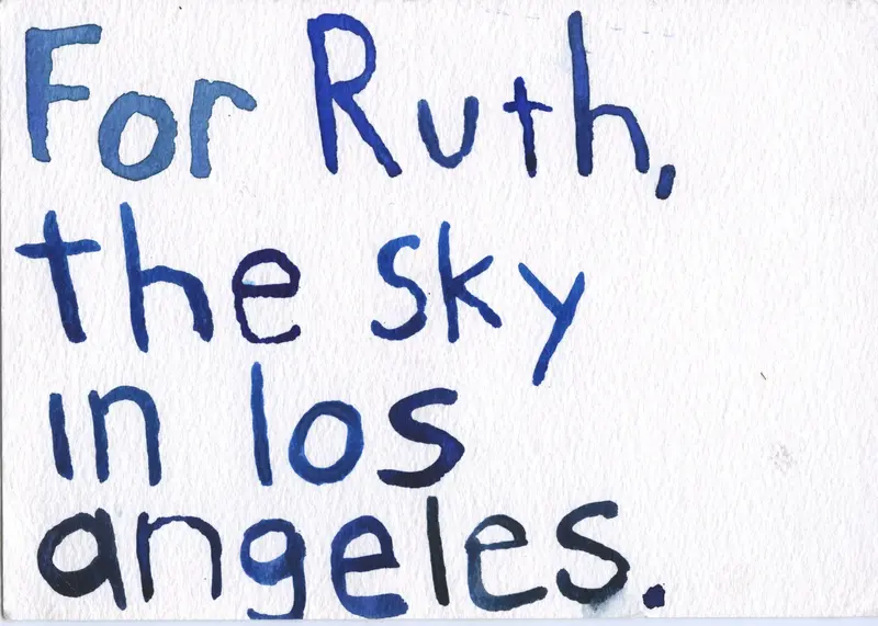 Weiße Postkarte mit blauer Schrift und den Worten For Ruth, the sky in los angeles