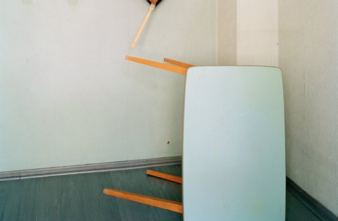 Foto mit einem umgekippten Tisch und einer Malerpalette an der Wand