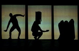 Schattenfiguren vor einem grünlichen Hintergrund