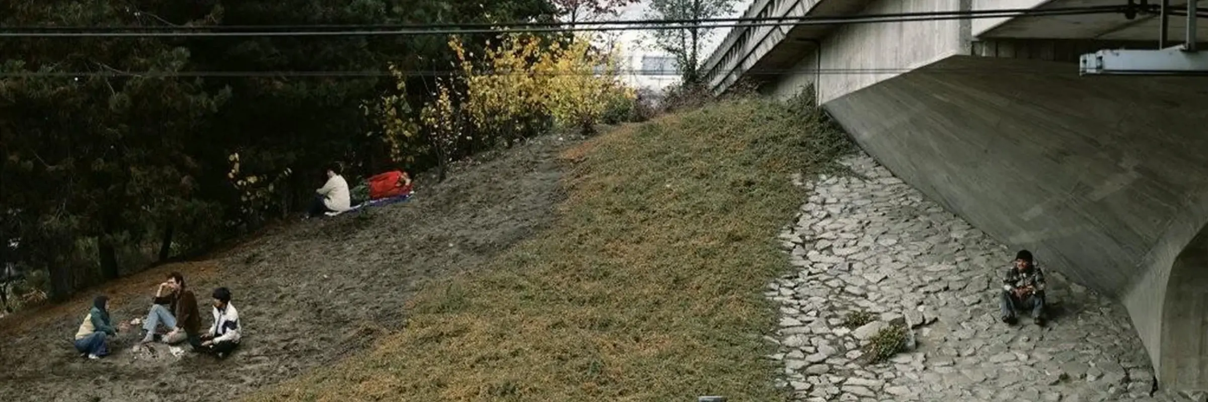 Foto mit nah an einer Brücke sitzenden Menschen