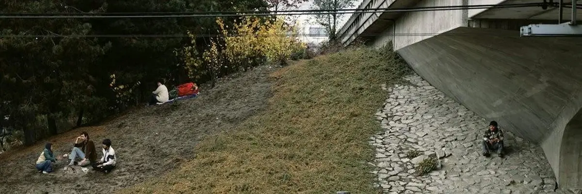 Foto mit nah an einer Brücke sitzenden Menschen