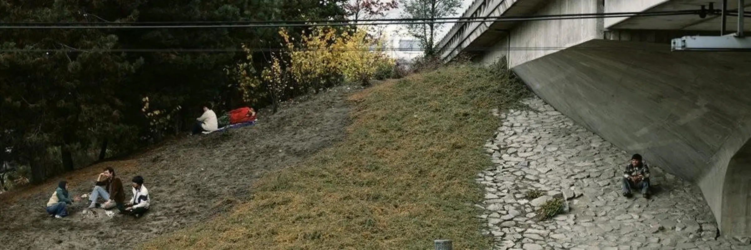 Foto mit nah an einer Brücke sitzenden Menschen