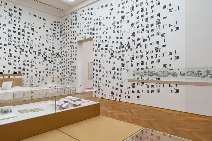 Eine Ausstellungsansicht  mit Stickern an der Wand 