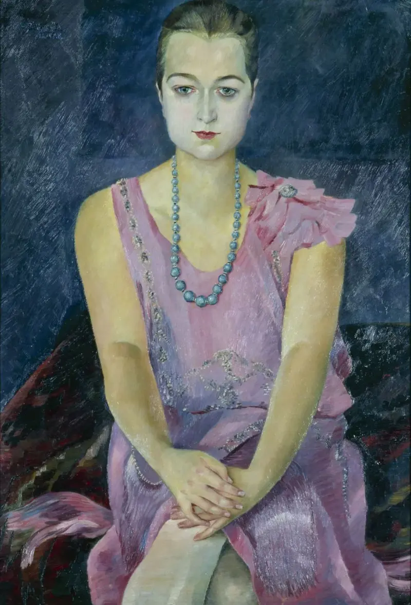 Frau, Dame, sitzend, Hände gefaltet, rosa Kleid, blaue Perlenkette, Schminke, Lippenstift, Strenge, Eleganz, zarter Stoff