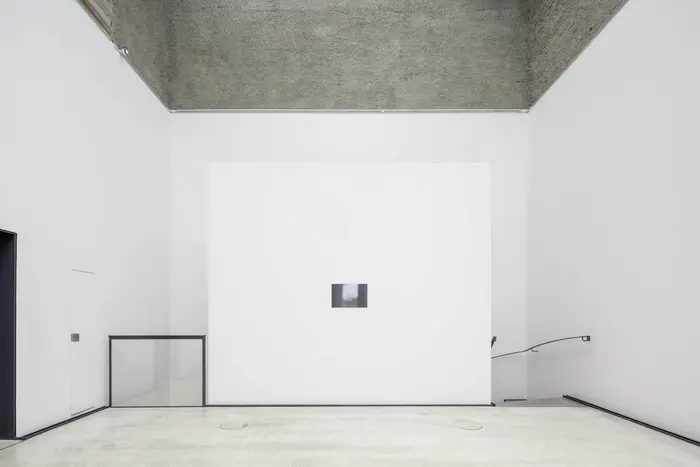 Eine Ausstellungsansicht  mit einem kleinen Bild an der Wand