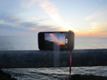 Foto eines Smartphones, das an ein Geländer geklebt ist und ein Video zeigt