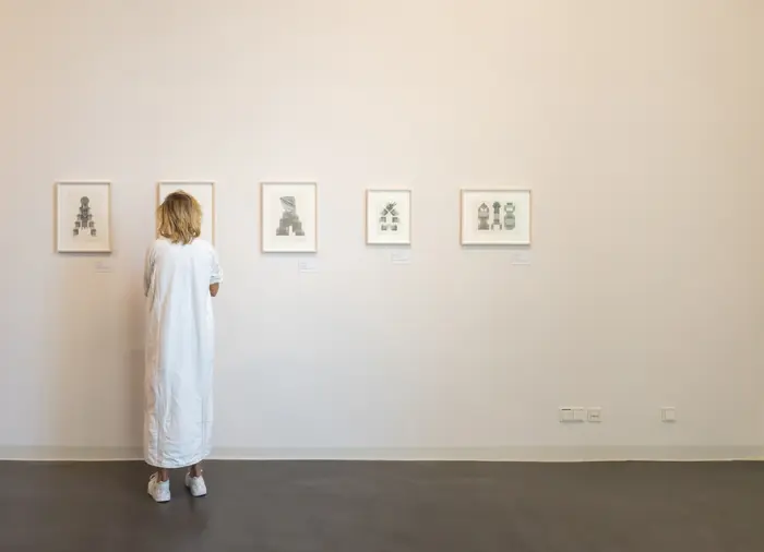 Eine Frau schaut sich Schreibmaschinengrafiken an