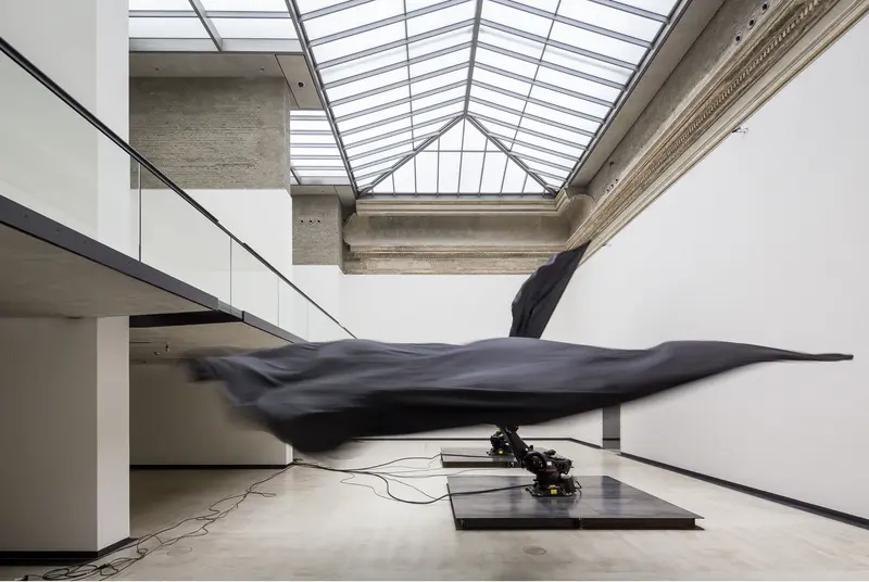 zwei Roboter-Arme mit schwarzen Flaggen