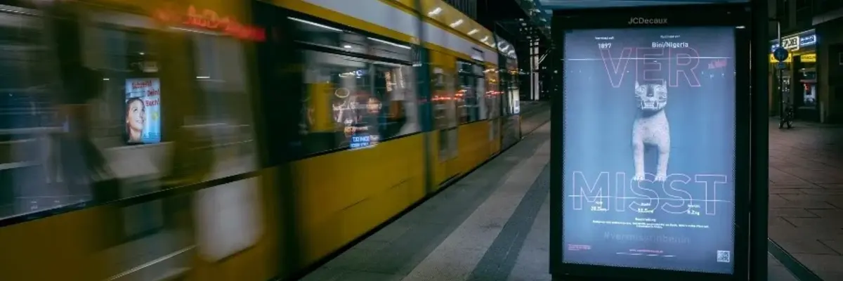 Eine Haltestelle mit Straßenbahn und einem Plakat mit der Aufschrift "Vermisst"