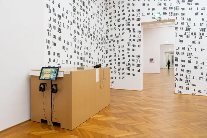 Eine Ausstellungsansicht  mit Stickern an der Wand 