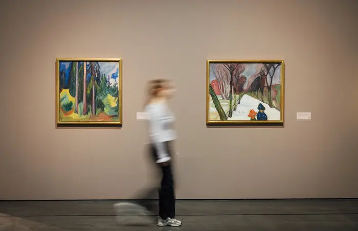 zwei Bilder an der Wand und eine Besucherin