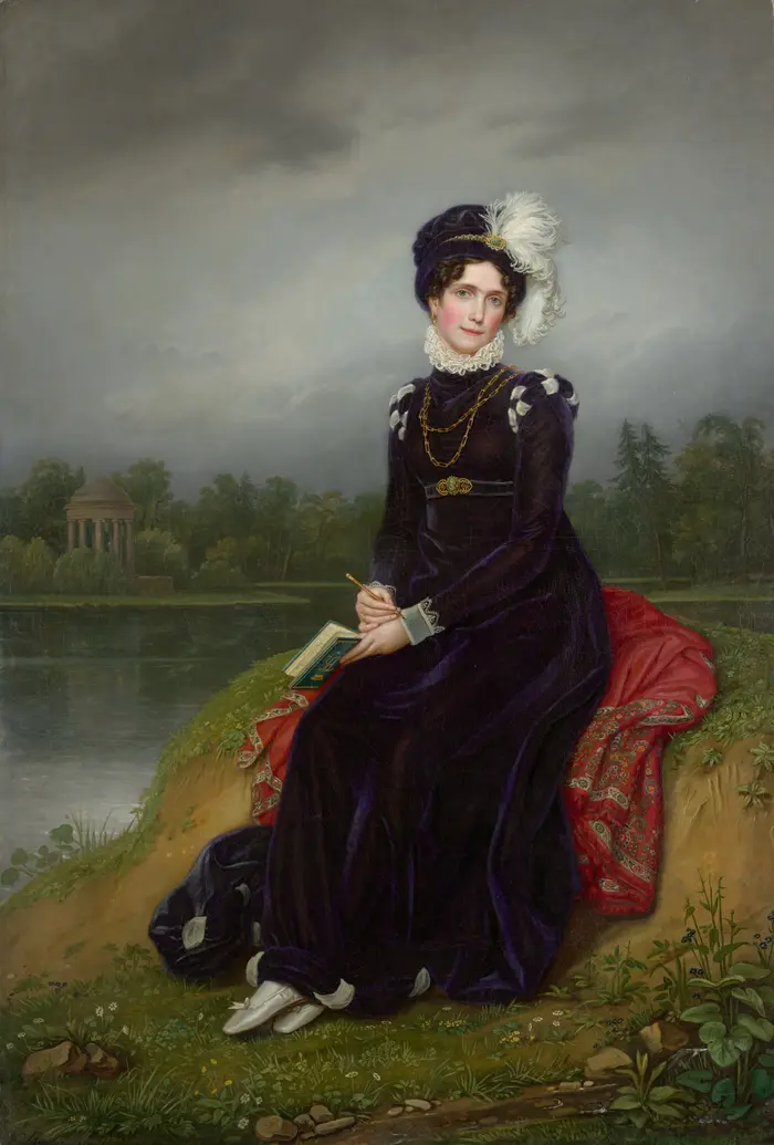 Dame in schwarz gekleidet sitzt in der Natur