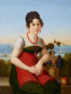 eine junge Frau neben einem Obstkorb sitzend, hinter ihr das Meer