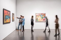 Ausstellungsansicht mit Besuchern und Gemälden